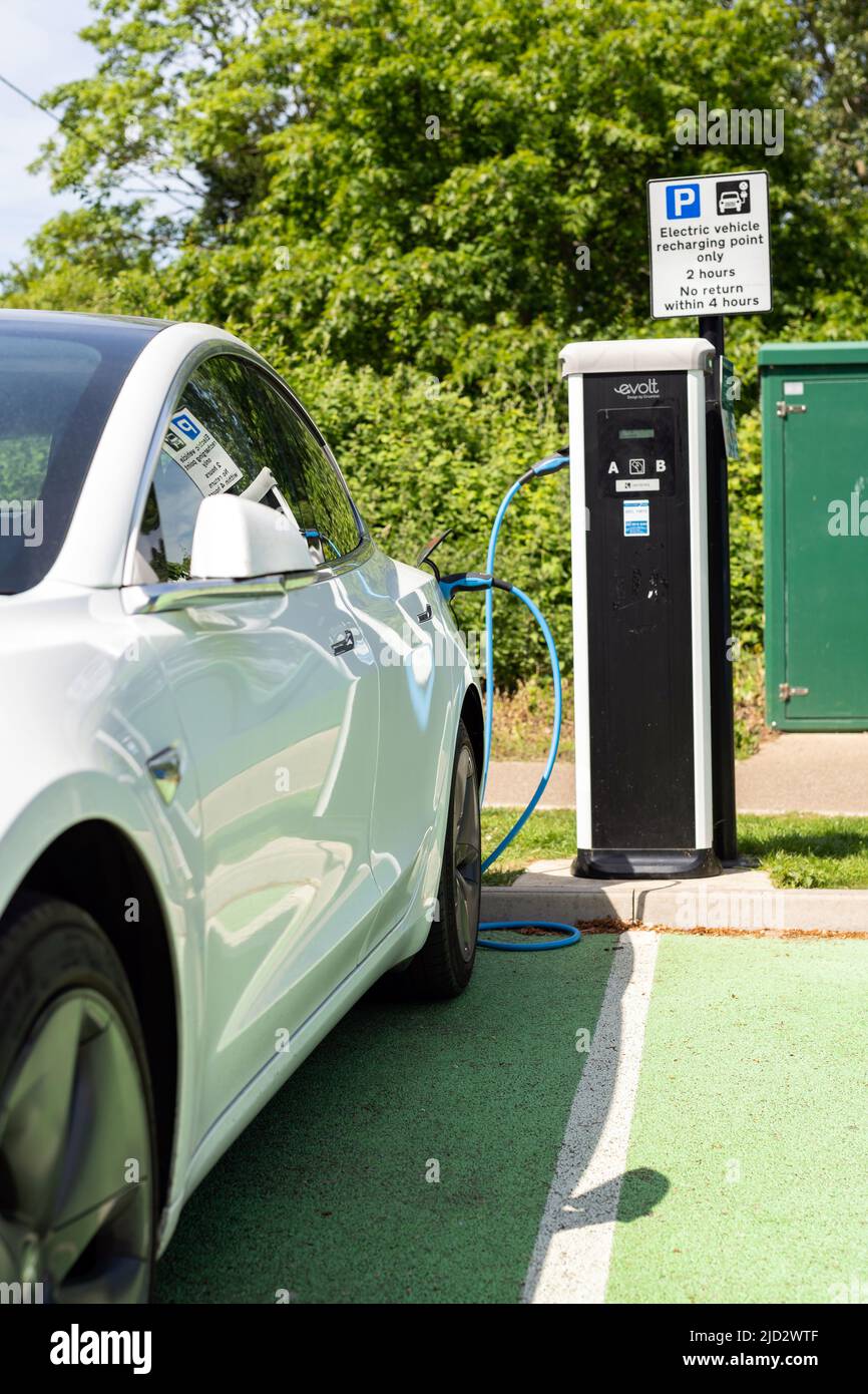 Woodbridge Suffolk Royaume-Uni Mai 18 2022: Une voiture électrique Tesla modèle 3 charge à la station de charge de branchement dans un parking public à Suffolk, Royaume-Uni Banque D'Images