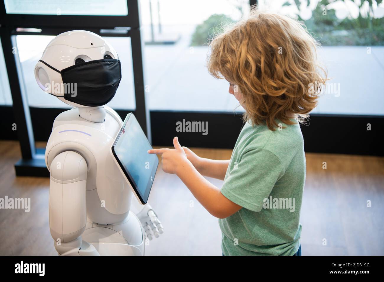 un gamin occupé interagit avec l'intelligence artificielle du robot, la communication Banque D'Images