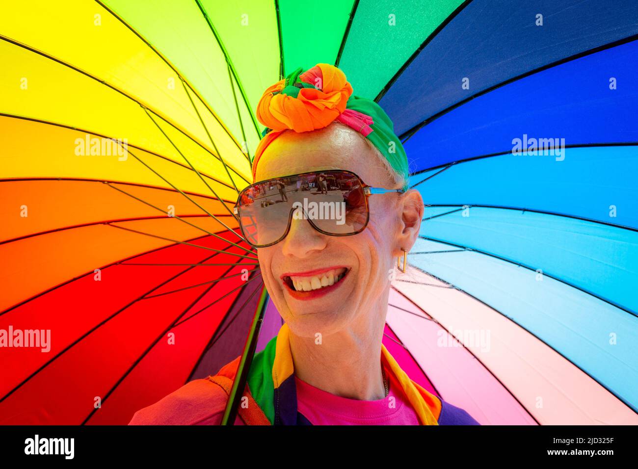 Homme ou femme transgenre avec un parapluie arc-en-ciel brillant, Royaume-Uni 2022 Banque D'Images