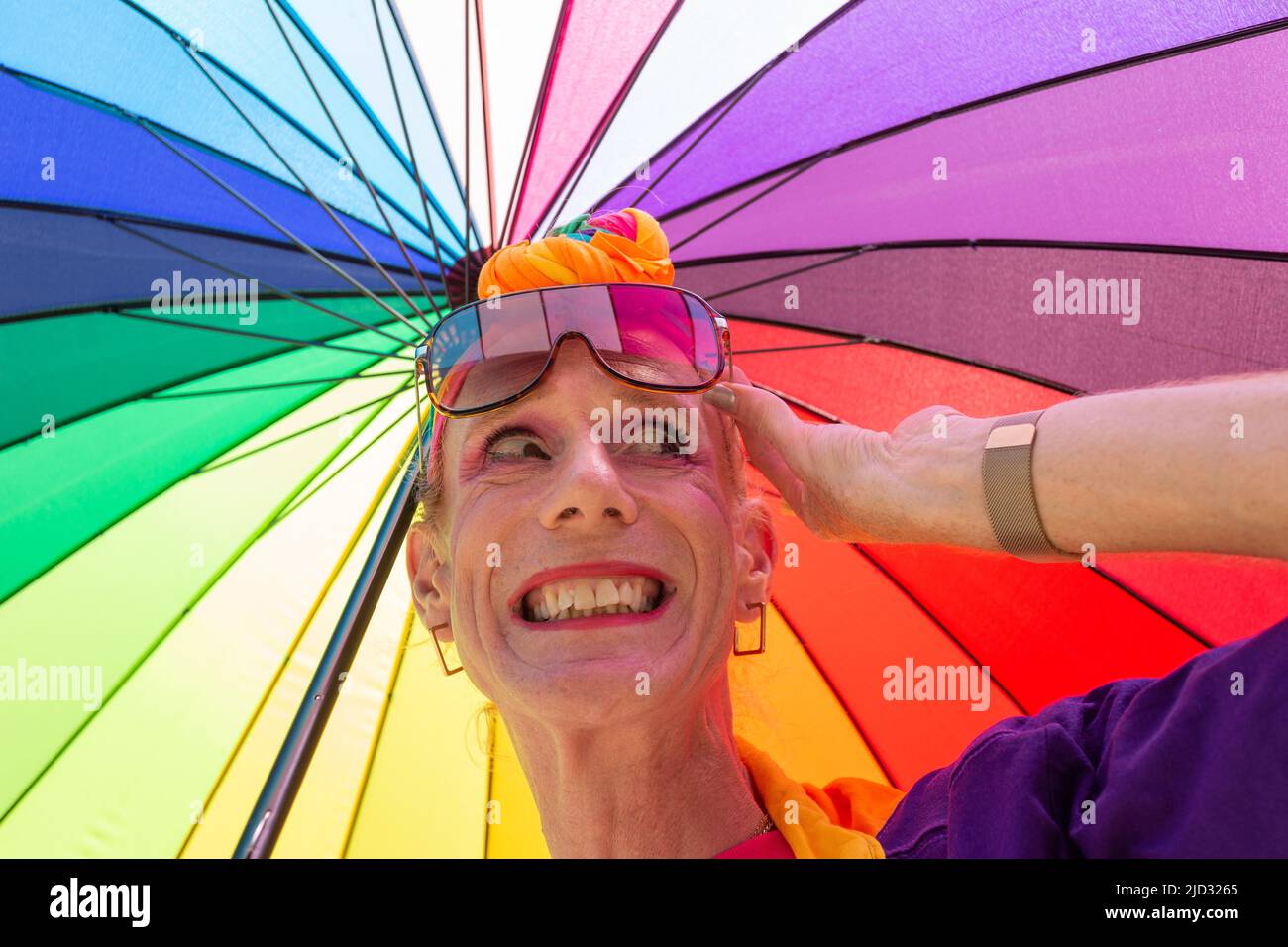 Homme ou femme transgenre avec un parapluie arc-en-ciel brillant, Royaume-Uni 2022 Banque D'Images