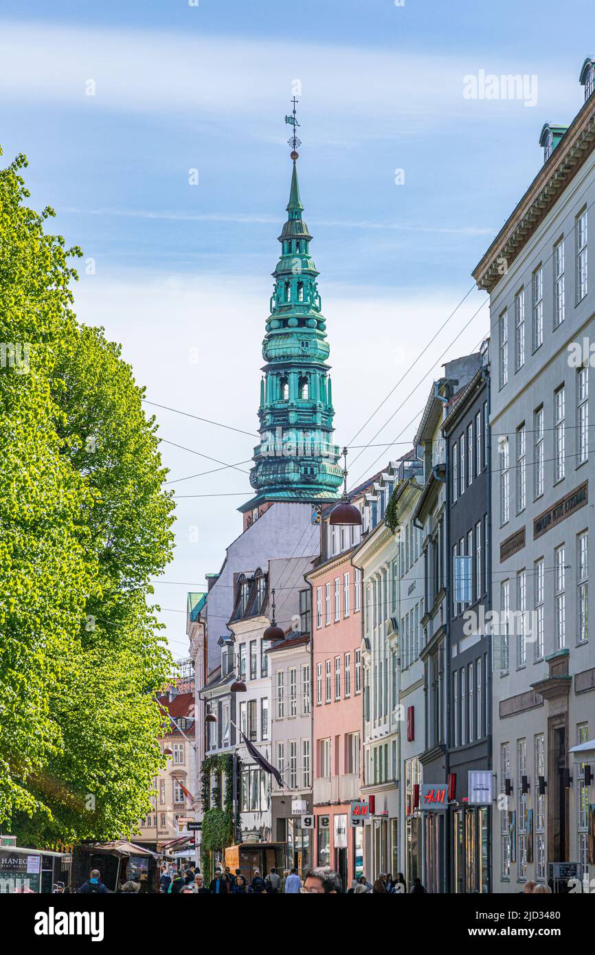 La tour et la flèche de l'ancienne église Saint Nicolas (aujourd'hui le centre d'art contemporain Nikolaj) dominant les boutiques d'Amagertorv. Copenhague, Danemark Banque D'Images