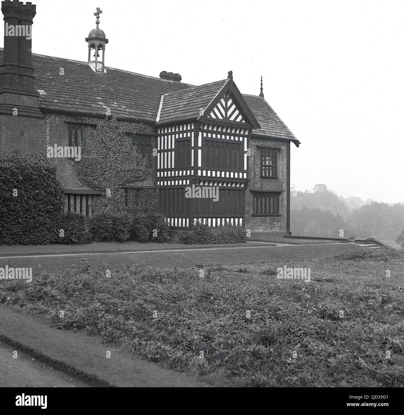 1940s, historique, à l'arrière de Bramall Hall, Stockport, Angleterre, Royaume-Uni. Un manoir Tudor à pans de bois qui date du 14th siècle, avec plus tard des ajouts, la maison et le parc environnant ont été acquis par les autorités locales en 1935 et sont devenus un musée. La famille Davenport, qu'on croit construire la maison, a tenu le manoir pendant plus de 500 ans. Banque D'Images