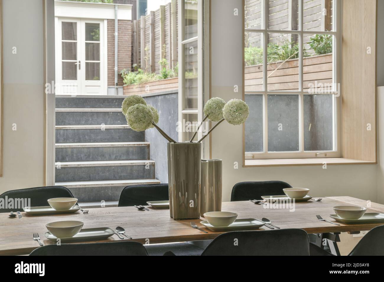 Salle à manger spacieuse et lumineuse avec vase élégant sur la table Banque D'Images