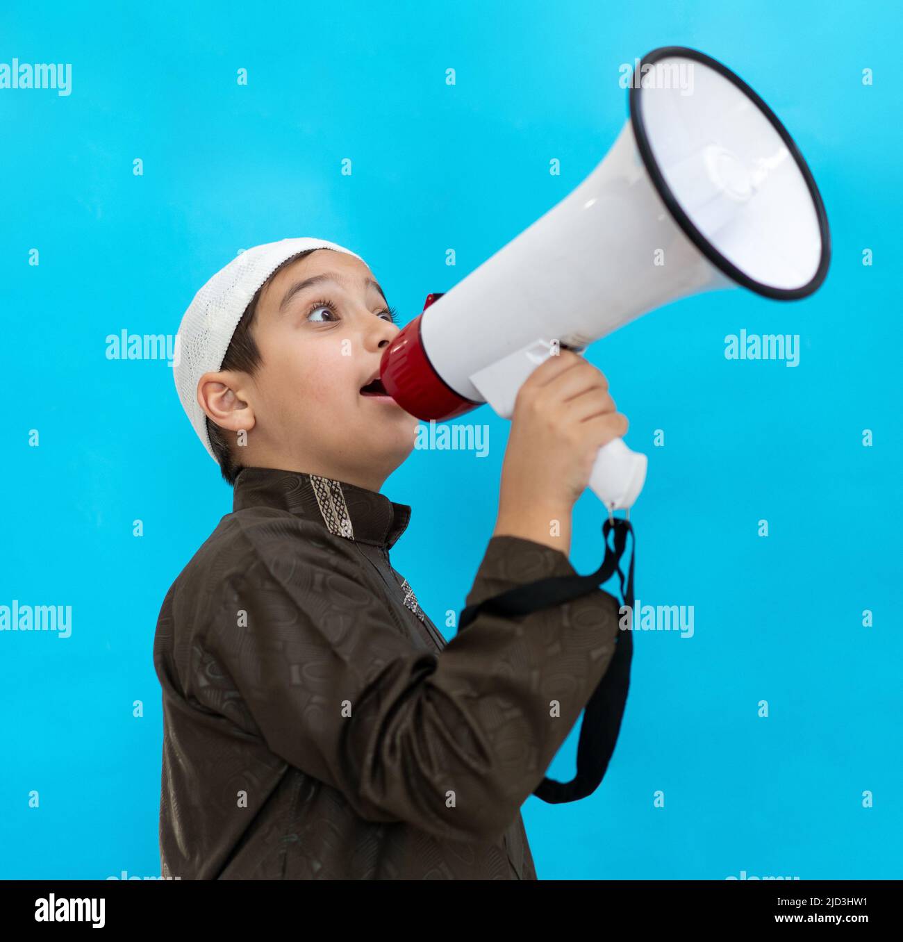 Petit garçon utilisant le mégaphone criant sur fond bleu. Photo de haute qualité Banque D'Images