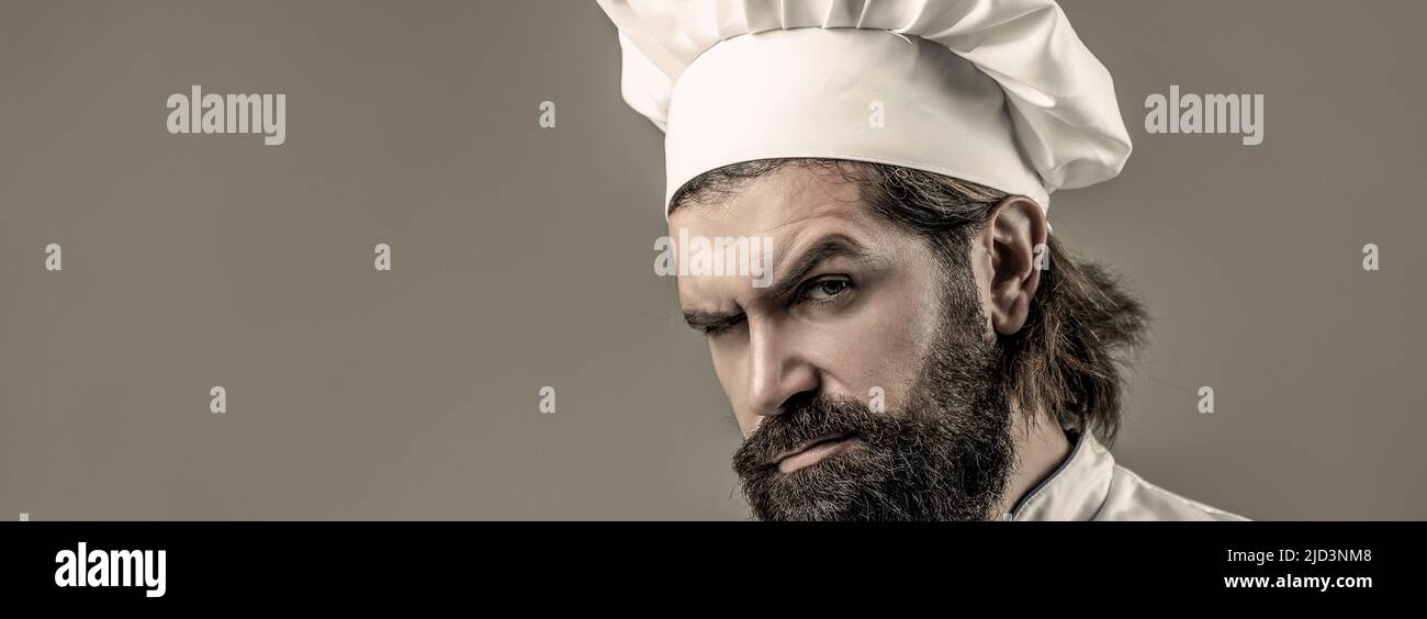 Chef mâle à barbe en uniforme blanc. Cuisinez sérieusement en uniforme blanc, chapeau de chef. Portrait d'un cuisinier sérieux Banque D'Images