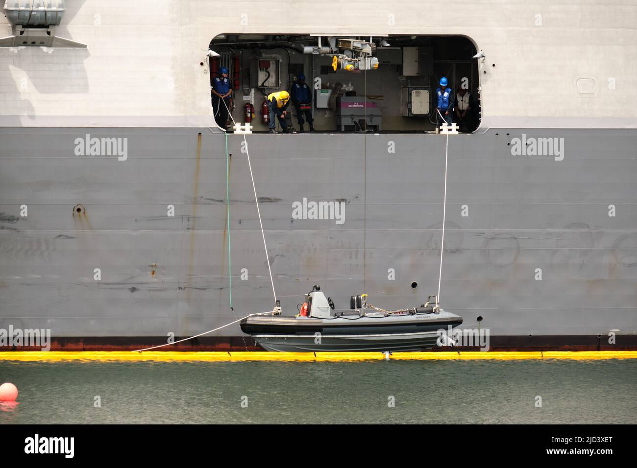 L'équipage de l'USS Minneapolis St-Paul abaisse le zodiaque sur l'eau Banque D'Images