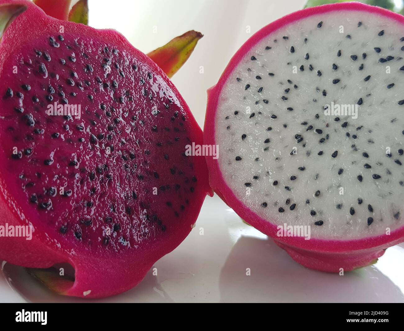 Fruit exotique asiatique pitahaya cactus rouge et blanc, coupé en deux. Pulpe et graines à l'extérieur, vue avant. Banque D'Images