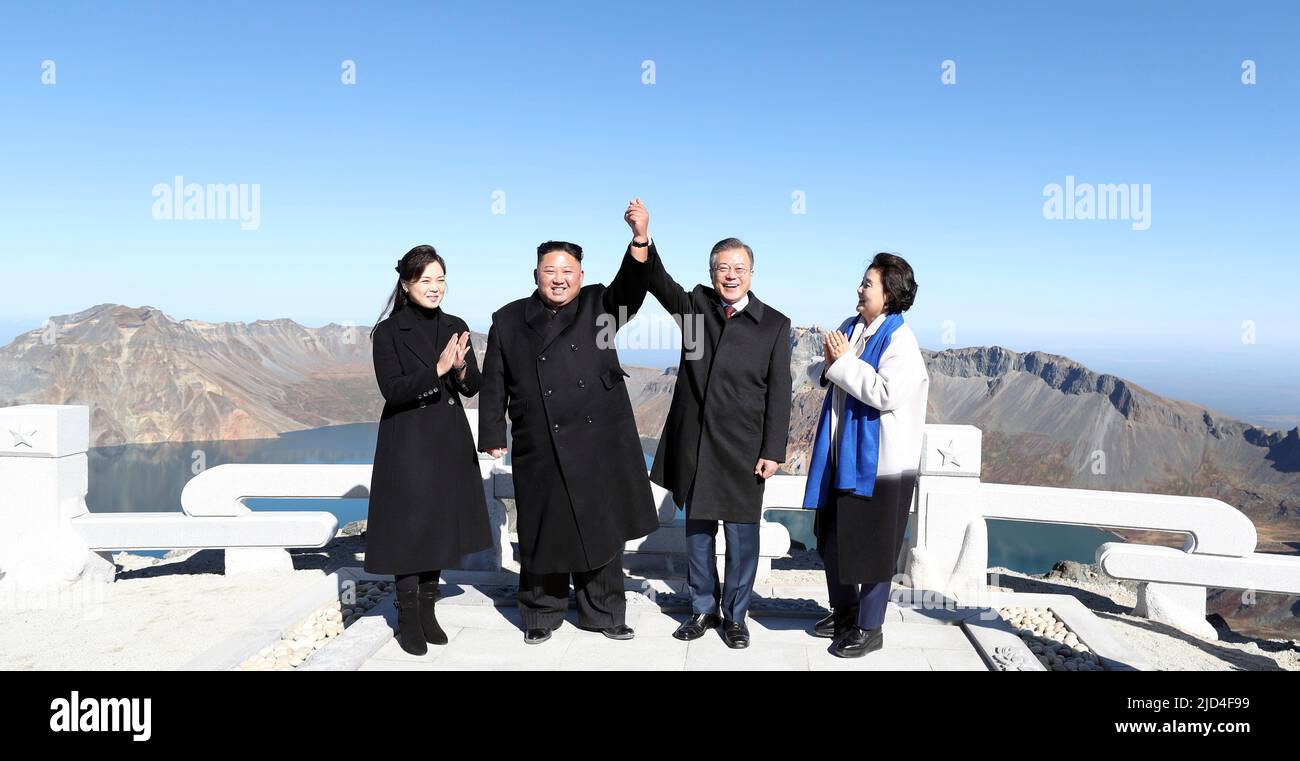 20 septembre 2018-montagne Baekdu, le président de la Corée du Nord Moon Jae-in et le dirigeant nord-coréen Kim Jong-un se sont élevés la main l'un sur le mont Paekdu, le sommet le plus élevé de la péninsule coréenne considéré comme le lieu de naissance du peuple coréen, dans un geste hautement symbolique soulignant leur engagement en faveur de la réconciliation et de l'unification. La visite conjointe a mis un terme puissant à la visite de trois jours de Moon au Nord qui a produit une série de résultats tangibles, y compris la promesse de Kim de prendre des mesures concrètes de dénucléarisation, comme le démantèlement du site d'essai ICBM du pays, et sa promesse de faire un réciproque Banque D'Images