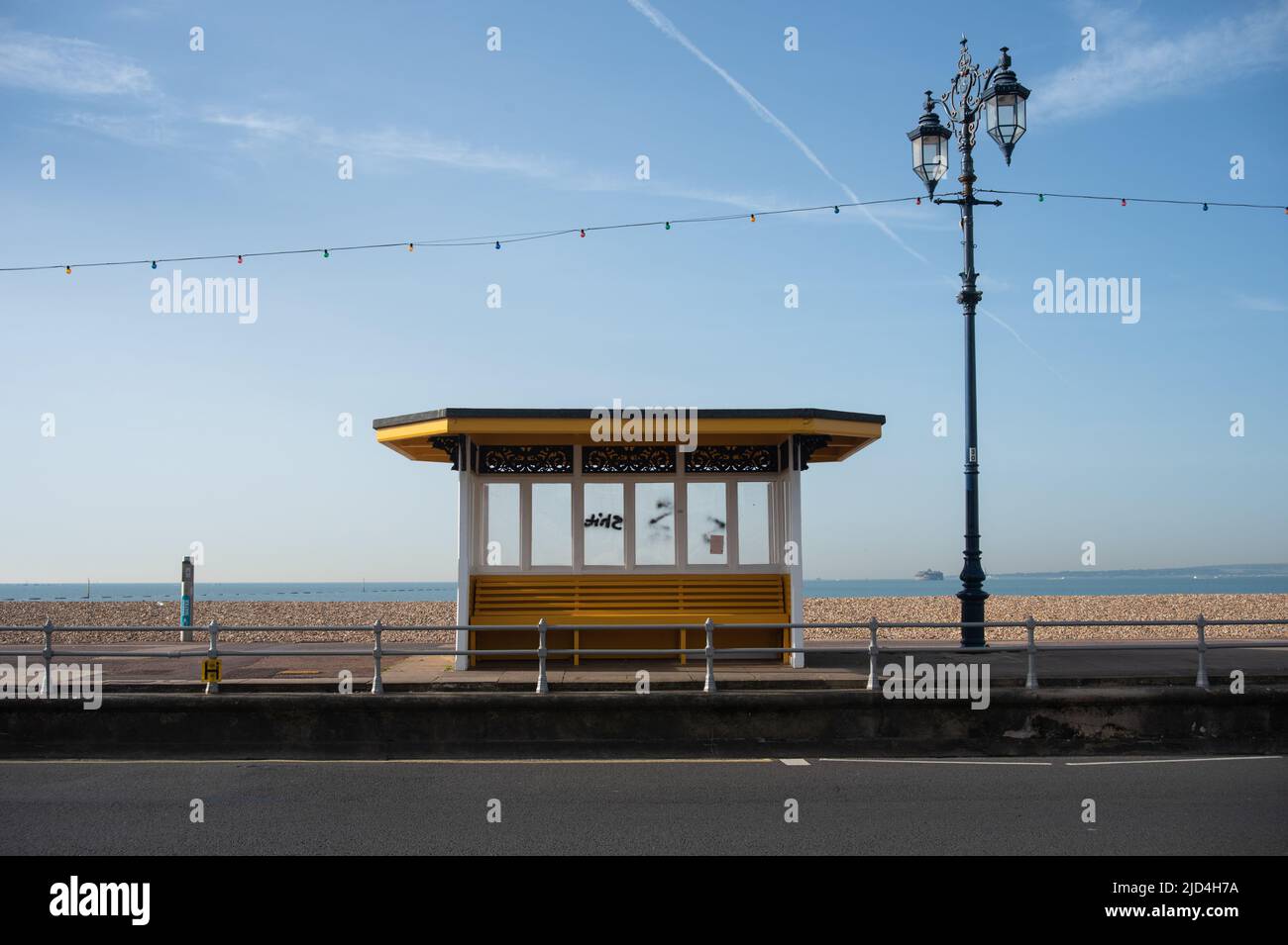 Un abri de vent isolé et un poste de lampe sur la promenade de Portsmouth, en Angleterre. Pas de gens et de l'île de Wight au loin. Banque D'Images