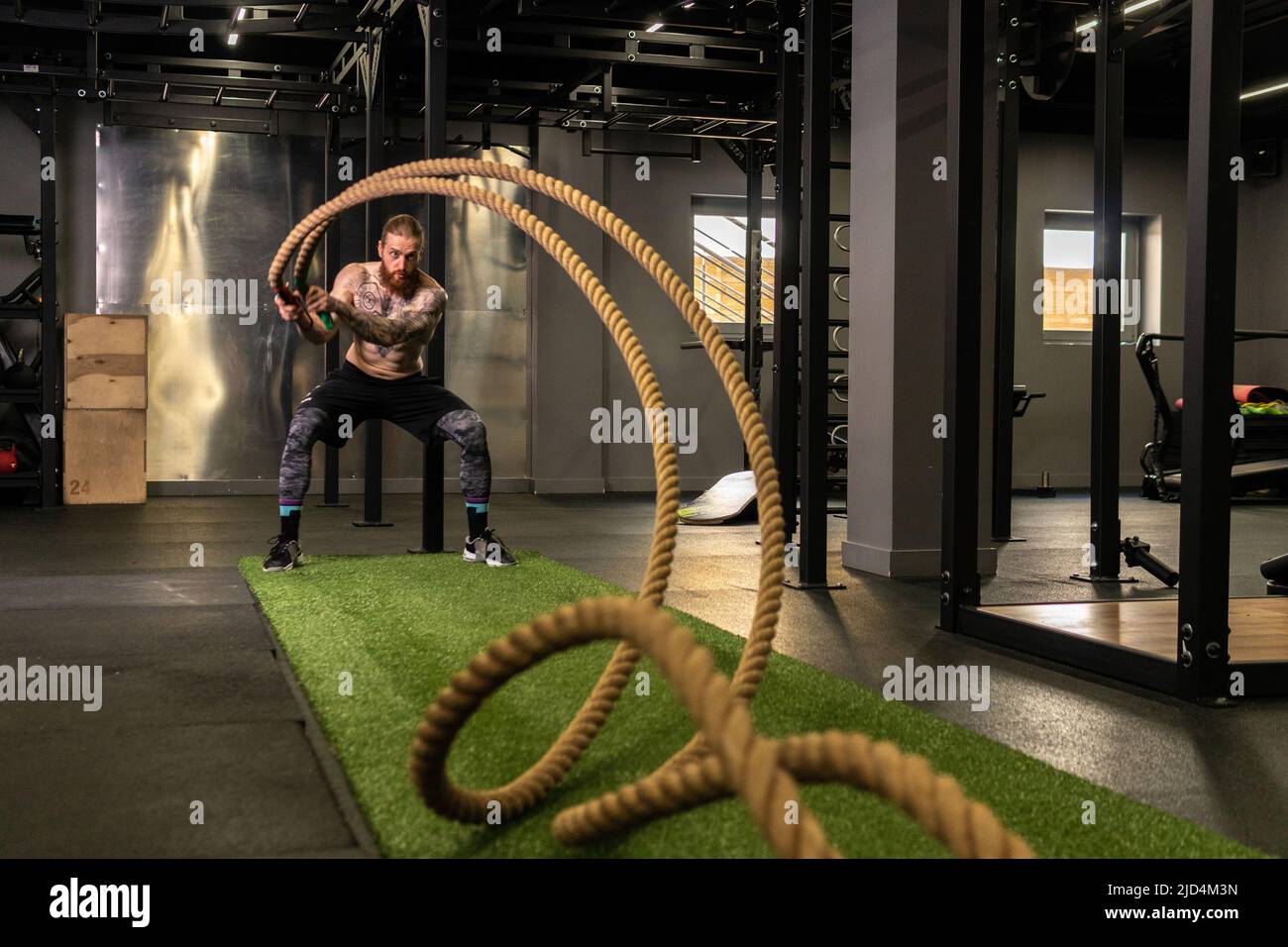 Corde entrepôt fitness homme vert herbe entraînement gym musculaire jeune, pour la force forte de l'activité physique saine, personne muscle. Croix Banque D'Images