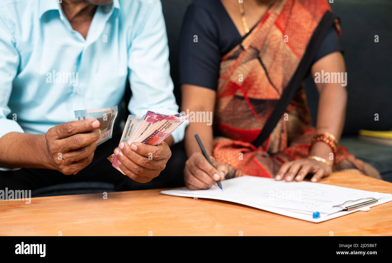 Gros plan sur les mains de couples Senior qui s'affairé à vérifier le budget ou les dépenses de factures à la maison - concprès de la gestion de l'argent, des investissements et des banques. Banque D'Images