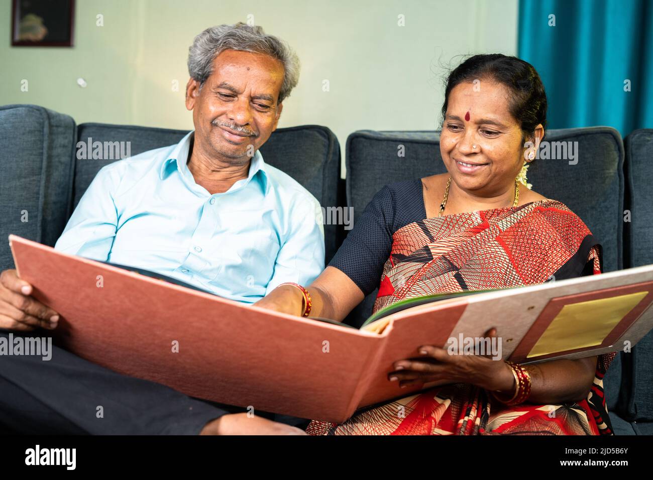 Heureux couple senior riant en regardant dans mariage album photo - concept de vieux souvenirs, nostalgique et de la famille de collage Banque D'Images