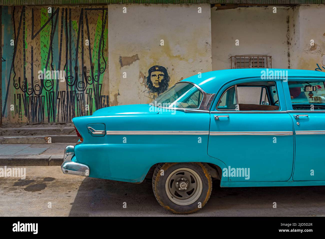 Une voiture bleue d'époque avec une fresque du Che Guevara en arrière-plan dans la vieille Havane, Cuba Banque D'Images