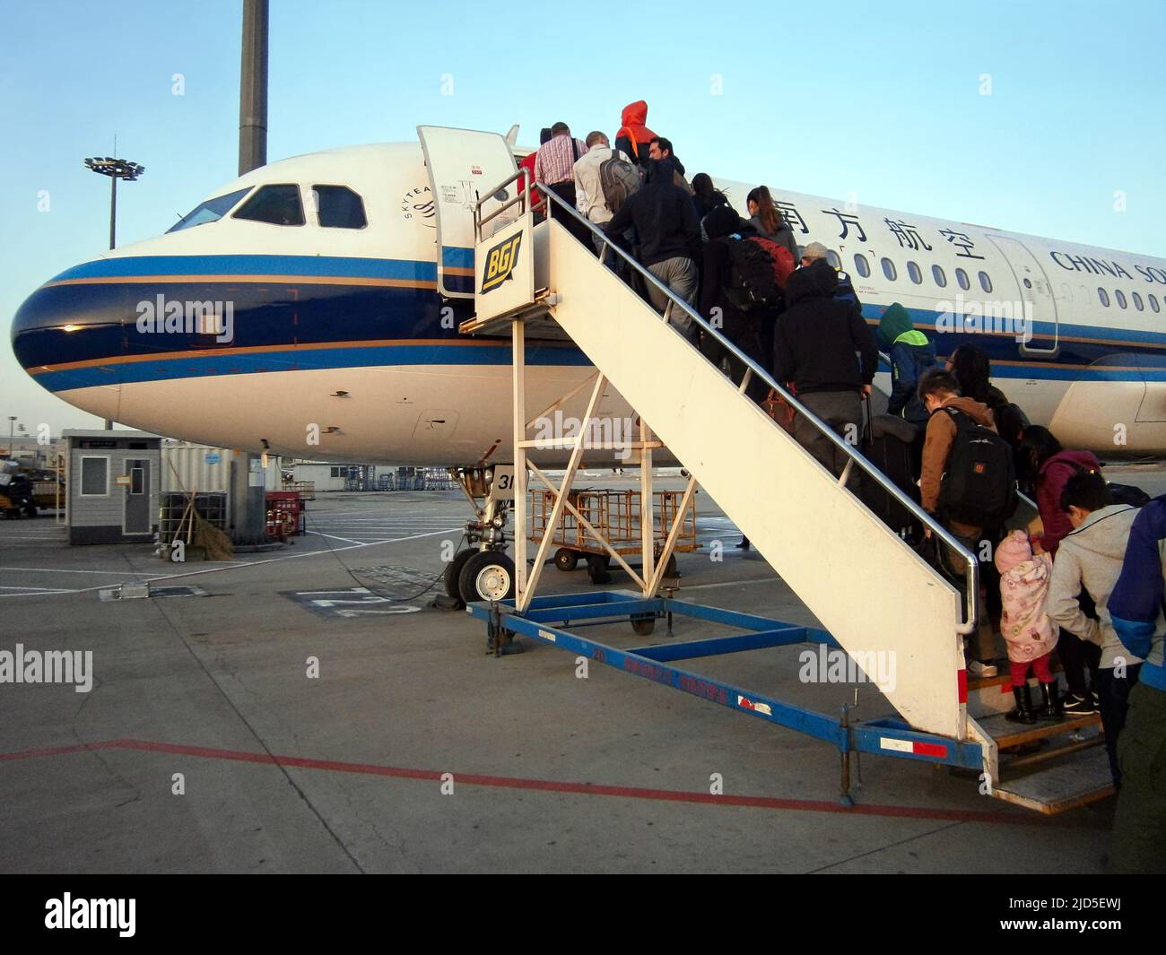 Les gens grimpent dans les escaliers d'un avion de ligne China Southern à l'aéroport Banque D'Images