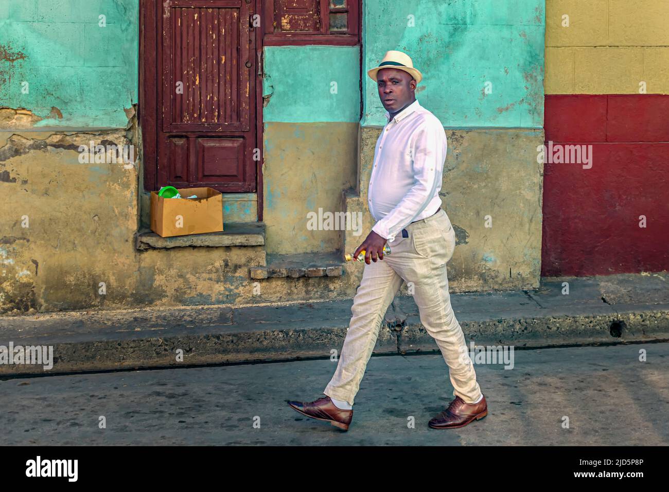 Un homme cubain avec chapeau marche dans les rues de Santiago de Cuba, Cuba Banque D'Images