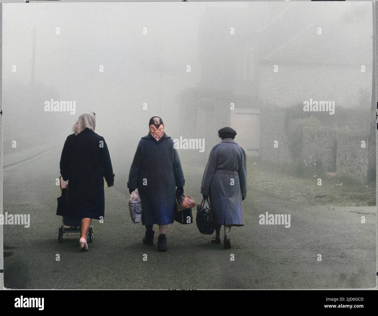 Trois vieilles dames qui rentrent à la maison dans le brouillard d'hiver avec leurs achats. Version colorisée de : 10171687 Date: 1960s Banque D'Images