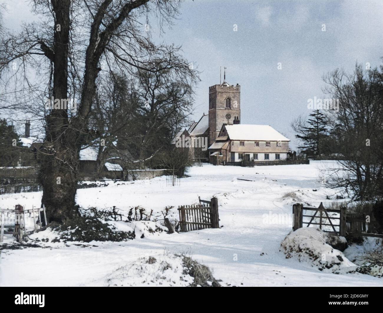 Une charmante scène de neige d'hiver, montrant l'église dans le petit village de Matching, Essex, Angleterre. Version colorisée de : 10187522 Date: 1950s Banque D'Images