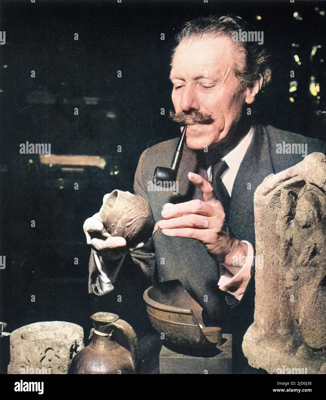 Portrait de Sir Mortimer Wheeler (1890 - 1976), archéologue et radiodiffuseur, assis à son bureau à l'Académie britannique. Par le biais de la télévision, Wheeler a réussi à apporter le sens de l'archéologie et une connaissance de l'antique à un très grand public et ainsi est devenu l'une des plus grandes étoiles de la télévision. Il a été brigadier au débarquement de Salerne en 1943 et a remporté le M.C. en 1917 en tant que commandant de batterie, et a été président de la Société des antiquaires et secrétaire de l'Académie britannique. La civilisation romaine était son sujet particulier, et il était professeur d'archéologie de la Banque D'Images