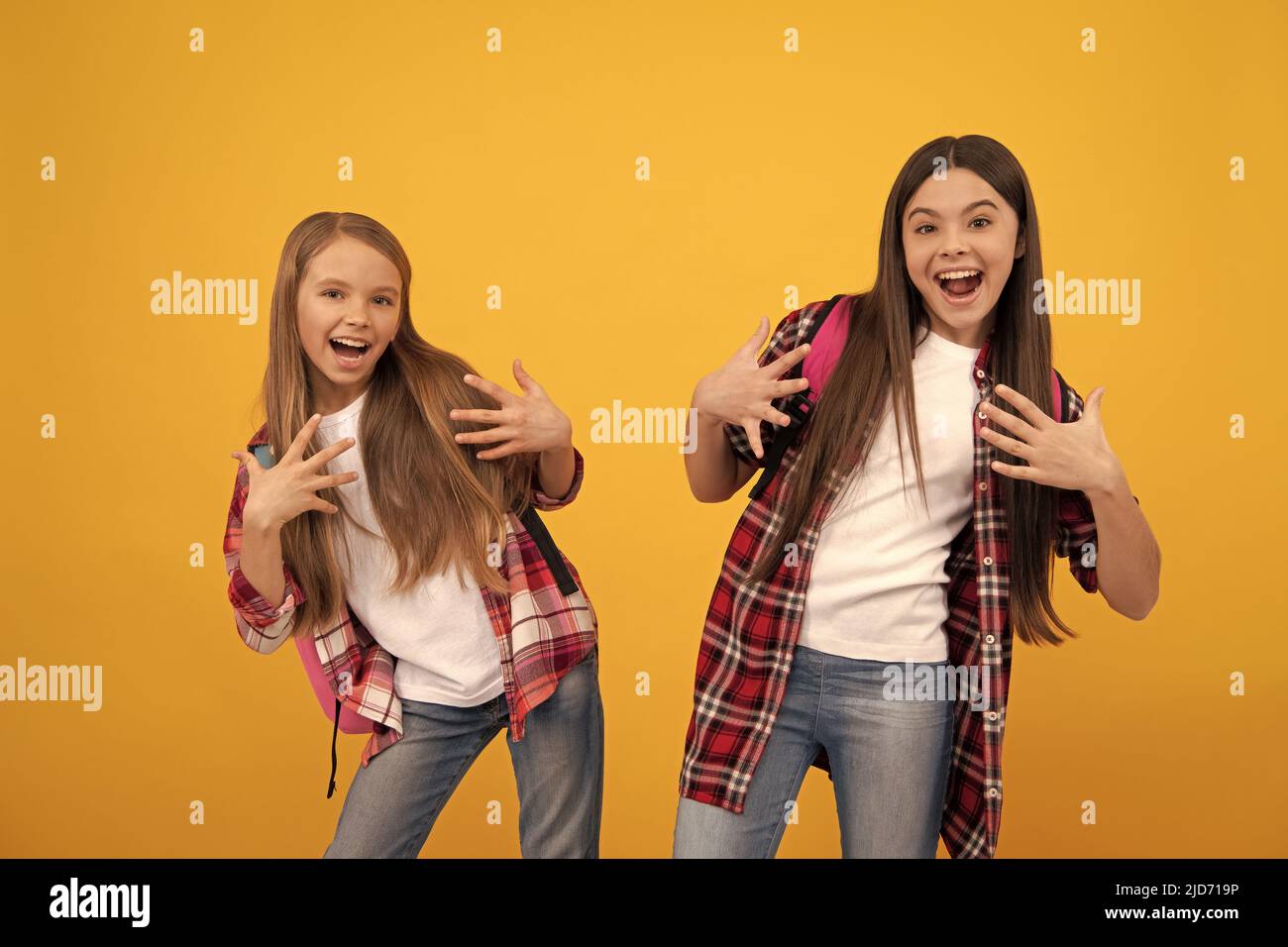 joyeux drôle adolescentes dans décontracté damier chemise porter sac à dos, l'amusement d'école Banque D'Images