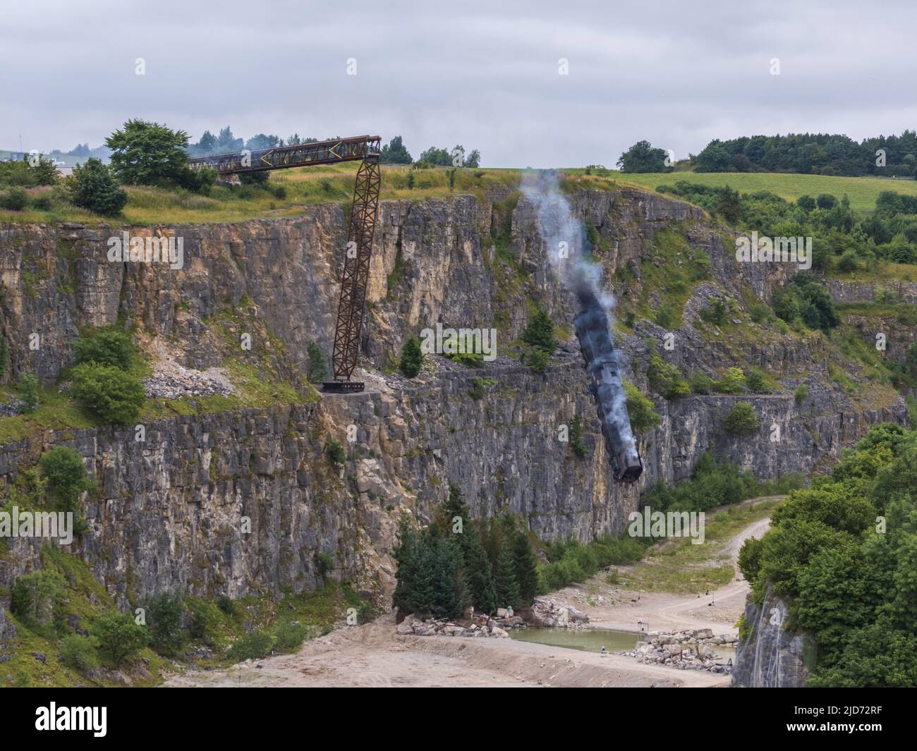 ***Vidéo disponible*** Mission: Impossible 7 scène d'accident de train de locomotive à Stoney Middleton, Derbyshire. La réplique du train à vapeur du British Railway Britannia est chassés de la falaise pour la scène finale de l'accident dans le dernier film à succès de Tom Cruise. La locomotive vole dans les airs dans un style spectaculaire avant de s'écraser dans la carrière ci-dessous. La scène a été filmée par deux hélicoptères et de nombreuses caméras à distance. Tom Cruise est arrivé juste avant la scène de l'accident final dans son hélicoptère personnel, il a voyagé autour du film avant d'atterrir dans les champs près de la voie ferrée au-dessus de la carrière. Le TR de vapeur Banque D'Images