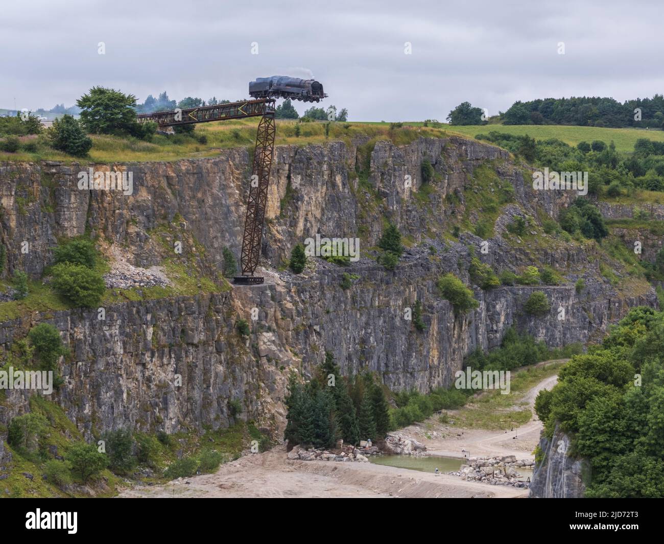 ***Vidéo disponible*** Mission: Impossible 7 scène d'accident de train de locomotive à Stoney Middleton, Derbyshire. La réplique du train à vapeur du British Railway Britannia est chassés de la falaise pour la scène finale de l'accident dans le dernier film à succès de Tom Cruise. La locomotive vole dans les airs dans un style spectaculaire avant de s'écraser dans la carrière ci-dessous. La scène a été filmée par deux hélicoptères et de nombreuses caméras à distance. Tom Cruise est arrivé juste avant la scène de l'accident final dans son hélicoptère personnel, il a voyagé autour du film avant d'atterrir dans les champs près de la voie ferrée au-dessus de la carrière. Le TR de vapeur Banque D'Images