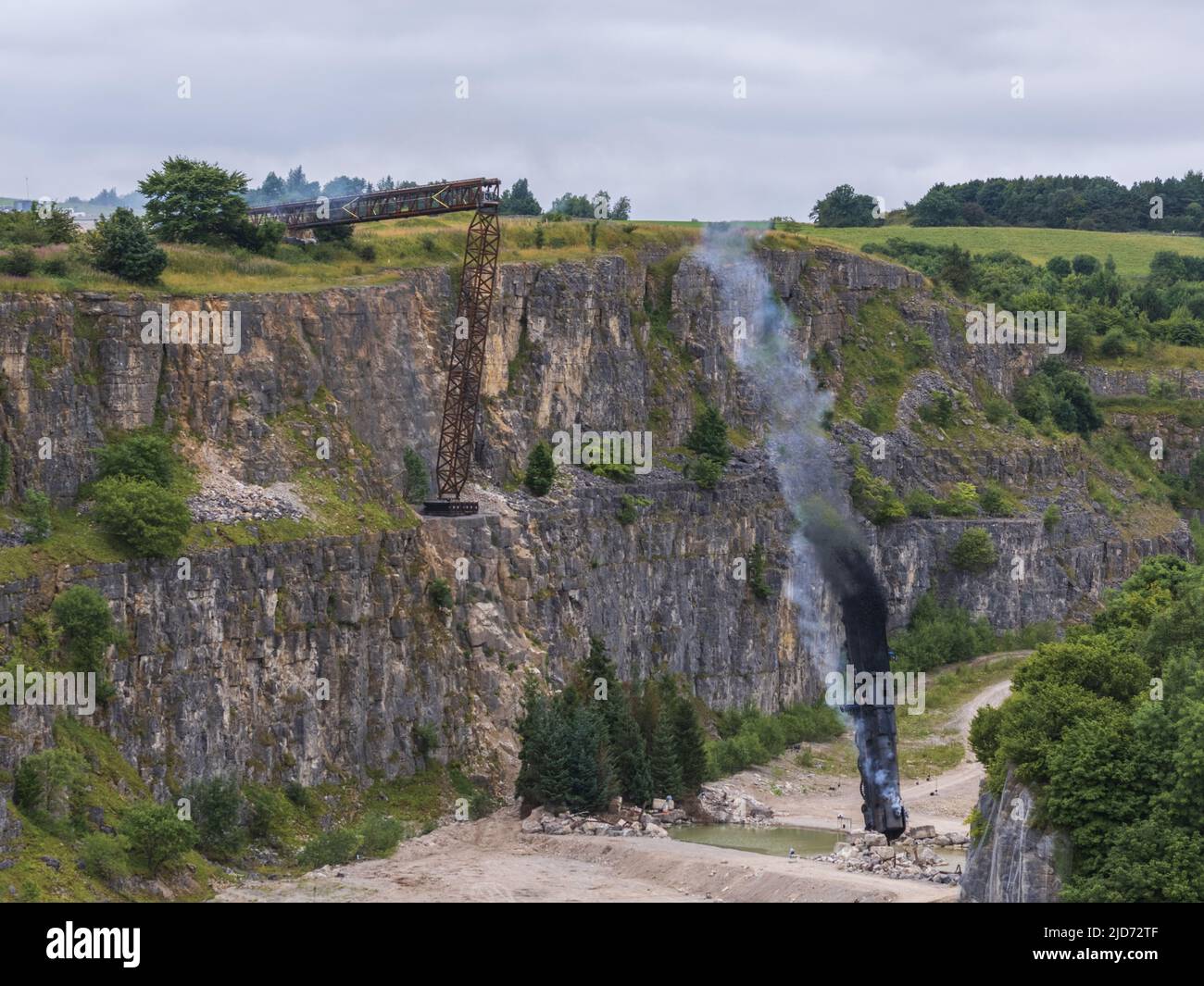 ***Vidéo disponible*** Mission: Impossible 7 scène d'accident de train de locomotive à Stoney Middleton, Derbyshire. La réplique du train à vapeur du British Railway Britannia est chassés de la falaise pour la scène finale de l'accident dans le dernier film à succès de Tom Cruise. La locomotive vole dans les airs dans un style spectaculaire avant de s'écraser dans la carrière ci-dessous. La scène a été filmée par deux hélicoptères et de nombreuses caméras à distance. Tom Cruise est arrivé juste avant la scène de l'accident final dans son hélicoptère personnel, il a voyagé autour du film avant d'atterrir dans les champs près de la voie ferrée au-dessus de la carrière. Le TR de vapeur Banque D'Images