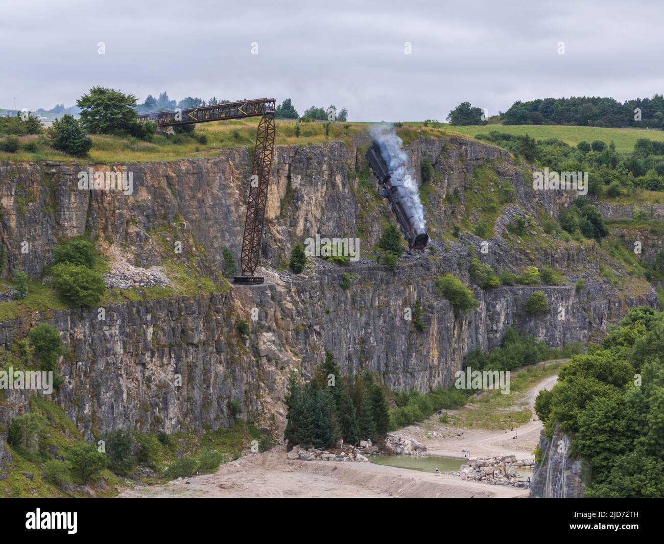 ***Vidéo disponible*** Mission: Impossible 7 scène d'accident de train de locomotive à Stoney Middleton, Derbyshire. La réplique du train à vapeur du British Railway Britannia est chassés de la falaise pour la scène finale de l'accident dans le dernier film à succès de Tom Cruise. La locomotive vole dans les airs dans un style spectaculaire avant de s'écraser dans la carrière ci-dessous. La scène a été filmée par deux hélicoptères et de nombreuses caméras à distance. Tom Cruise est arrivé juste avant la scène de l'accident final dans son hélicoptère personnel, il a voyagé autour du film avant d'atterrir dans les champs près de la voie ferrée au-dessus de la carrière. Le TR de vapeur Banque D'Images