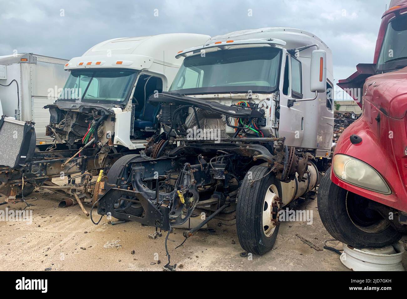 Trois camions brisés dans une cour à risque après un accident, ont jeté des voitures de récupération avec des moteurs en panne. Parc extérieur avec débris de pièces d'épave d'automobiles Banque D'Images