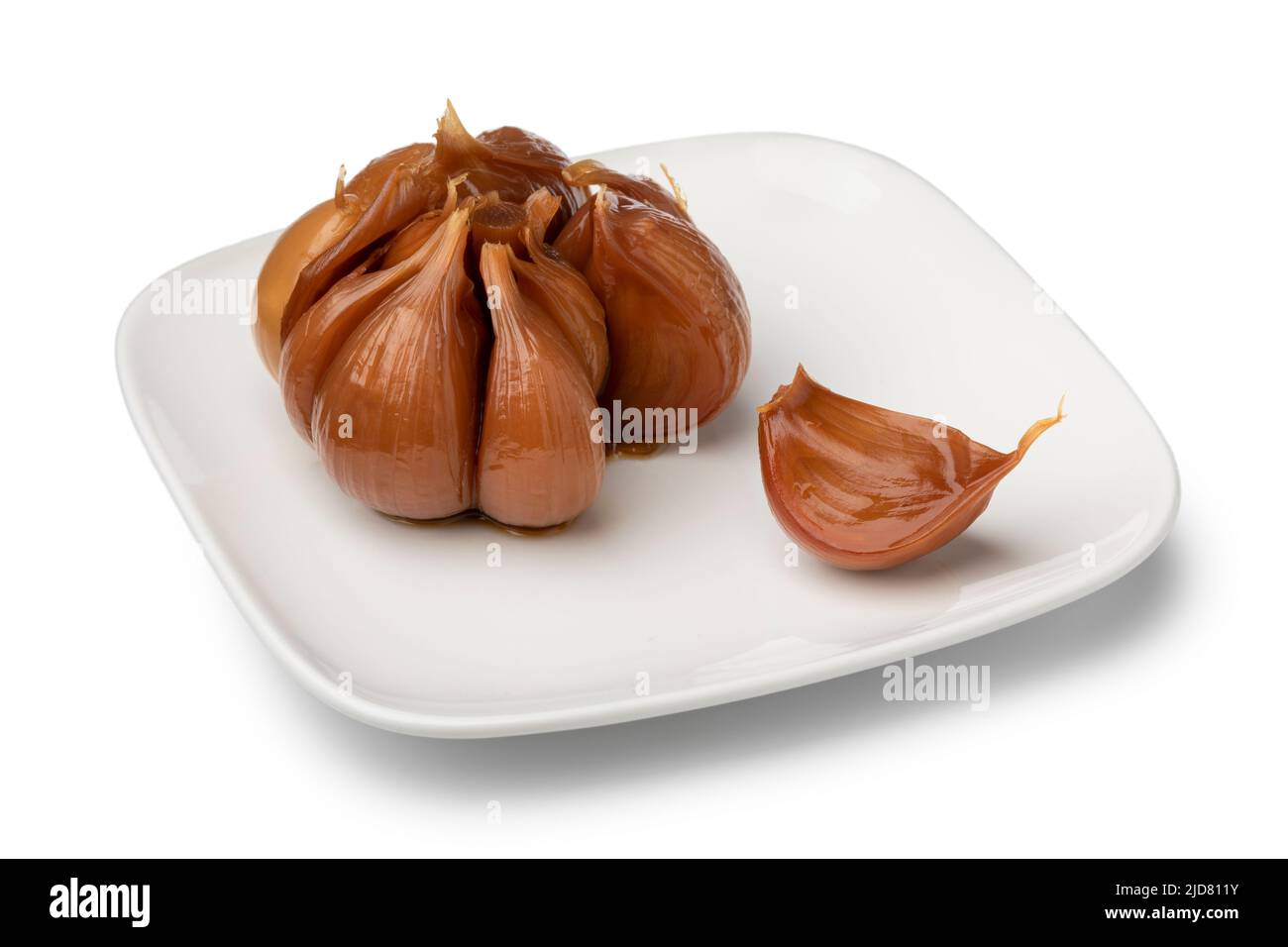 Assiette avec une poire à ail marinée et une gousse isolée sur fond blanc Banque D'Images