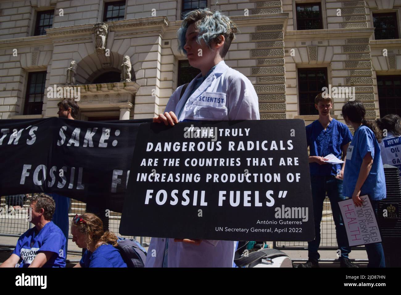 Londres, Royaume-Uni. 11th juin 2022. Un manifestant détient un écriteau avec une citation sur les combustibles fossiles du Secrétaire général de l'ONU Antonio Guterres. Les manifestants devant le Trésor. Extinction les médecins, les infirmières et les autres professionnels de la santé se sont réunis pour protester à Westminster afin d'exiger la fin des investissements dans les combustibles fossiles. Banque D'Images