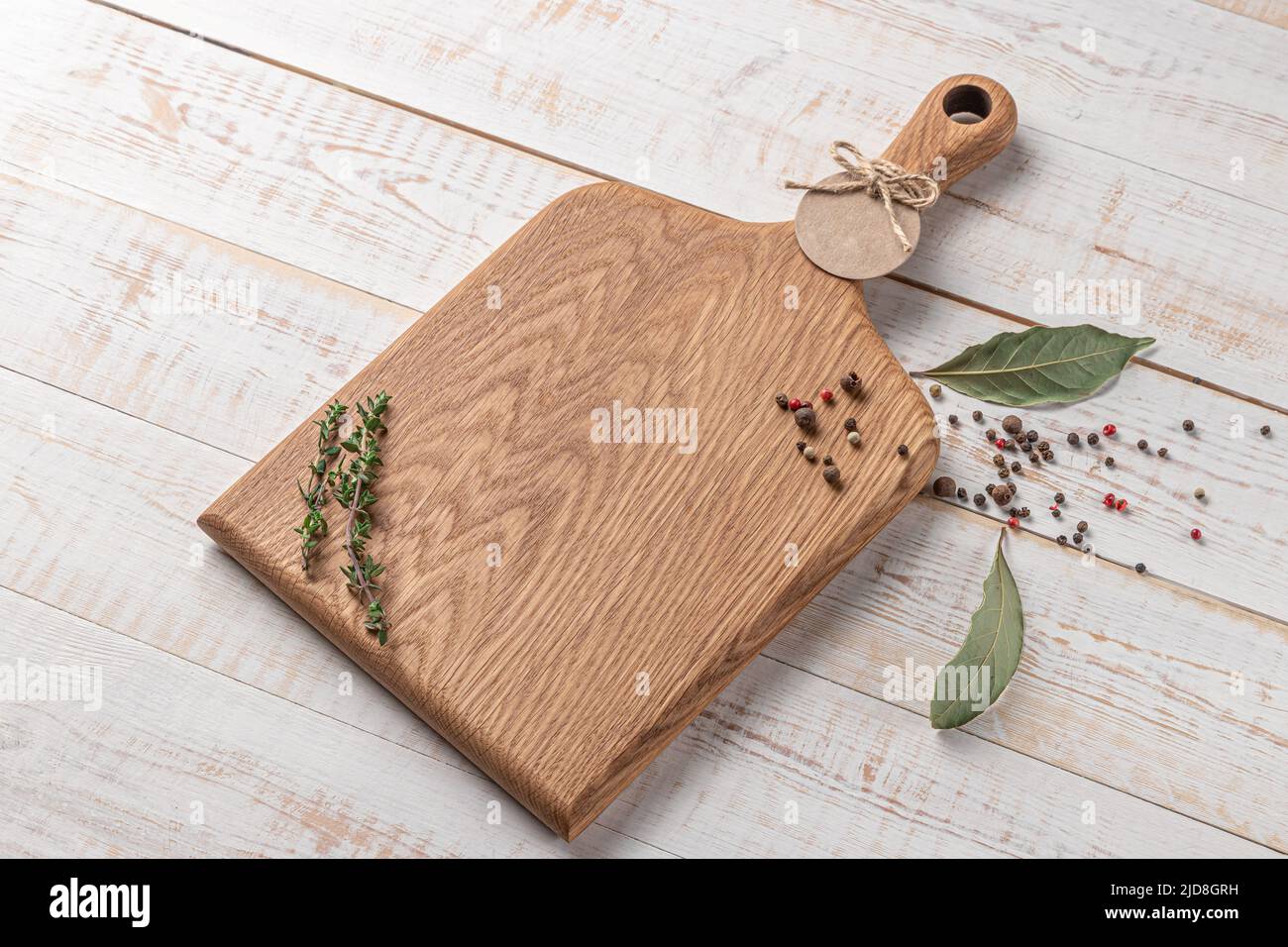 planche à découper carrée en bois avec poignée et épices sur fond blanc. maquette avec espace pour le texte, vue latérale Banque D'Images