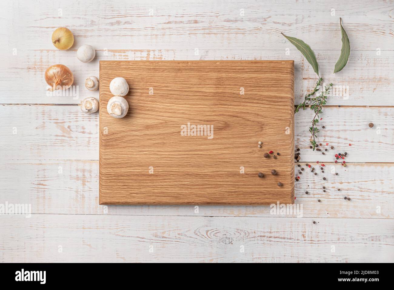 planche à découper carrée en bois avec champignons et épices sur fond blanc. maquette avec espace pour le texte, vue de dessus Banque D'Images