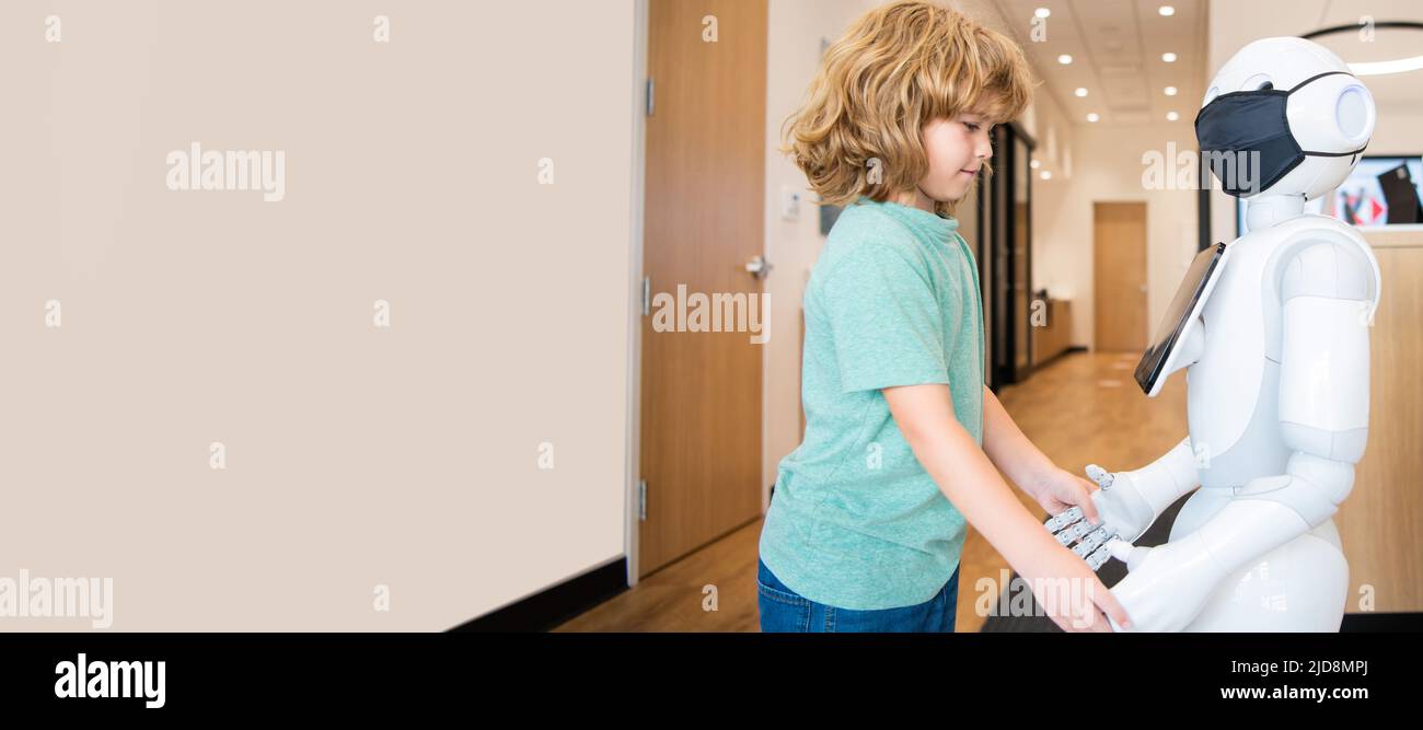 un petit garçon interagit avec le robot comme une technologie innovante, la communication. Affiche horizontale. En-tête de bannière Web, espace de copie. Banque D'Images