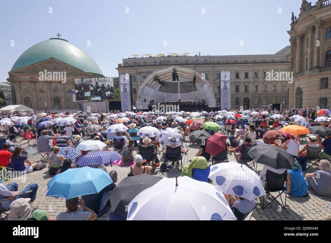 19 juin 2022, Berlin: De nombreuses personnes qui sont venues à l'Opéra de Sate pour tous sur Bebelplatz se protègent de la chaleur avec des parasols. Photo: Joerg Carstensen/dpa Banque D'Images