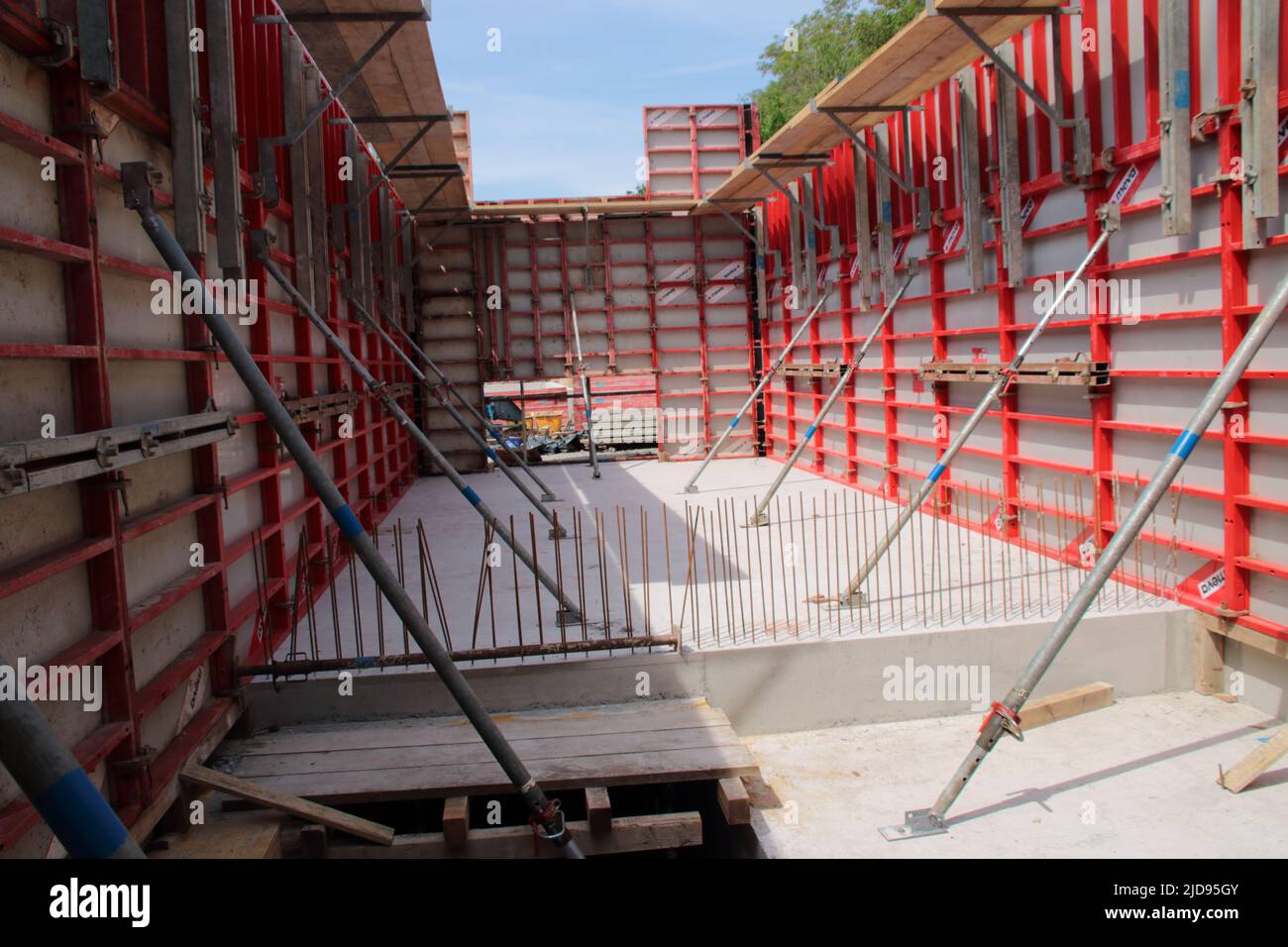 Le coffrage d'un mur en béton a été fixé pour éviter qu'il ne glisse à l'aide de béquilles Banque D'Images