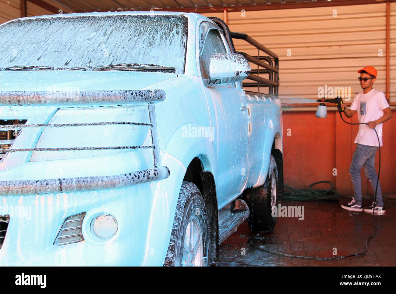 Windhoek, Namibie. 18th juin 2022. Un homme lave une voiture avec des savons colorés à Windhoek, Namibie, sur 18 juin 2022. POUR ALLER AVEC 'l'entrepreneur namibien utilisant des savons de couleur pour le lavage de voiture pour conduire des affaires" crédit: Musa C Kaseke/Xinhua/Alay Live News Banque D'Images