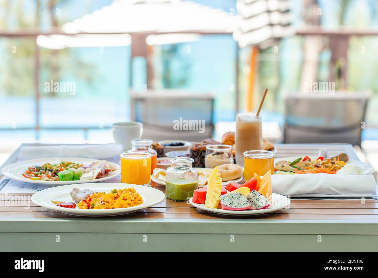 Délicieux petit déjeuner sur une table en bois à côté de la piscine avec vue sur la mer Banque D'Images
