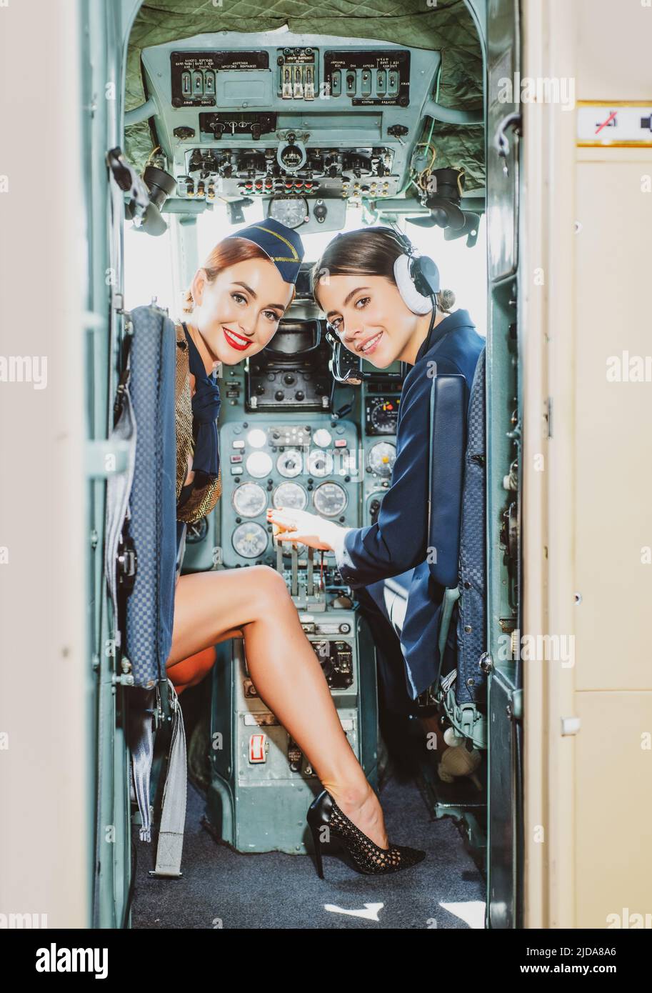 Deux pilotes féminins sourit et souhaitent un vol réussi. Pilote stagiaire et instructeur de vol dans un cockpit d'avion. Elle tient le casque d'aviateur et Banque D'Images