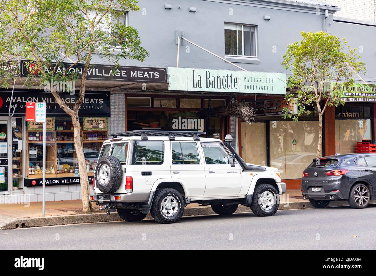 2016 modèle blanc Toyota Landcruiser garée à l'extérieur boulangerie et boucherie magasin à Avalon Beach, Sydney, Nouvelle-Galles du Sud, Australie Banque D'Images