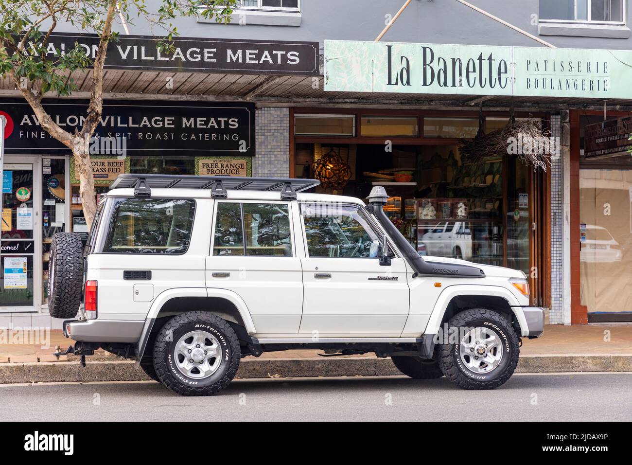 2016 modèle blanc Toyota Landcruiser garée à l'extérieur boulangerie et boucherie magasin à Avalon Beach, Sydney, Nouvelle-Galles du Sud, Australie Banque D'Images
