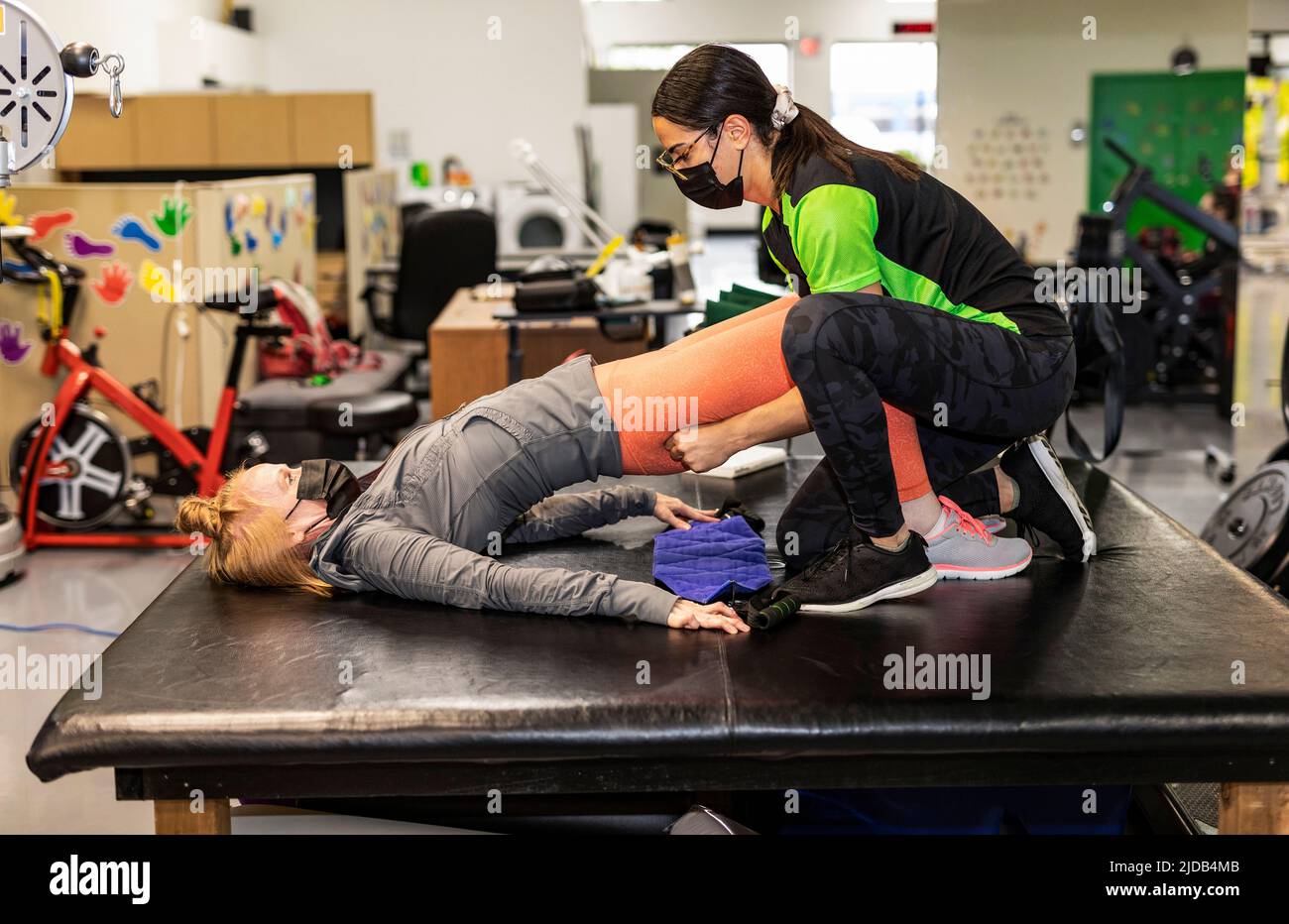 Une femme paraplégique qui fait des propulseurs de hanche assistés avec son entraîneur: Edmonton, Alberta, Canada Banque D'Images