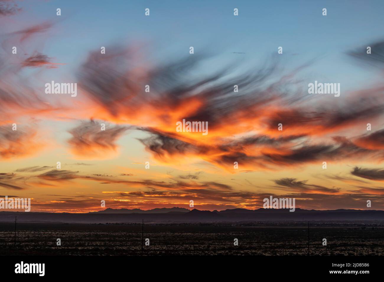 Un coucher de soleil près de Las Cruces, Nouveau-Mexique avec des nuages de cirrus incandescents montrant l'effet Virga ; Las Cruces, Nouveau-Mexique, États-Unis d'Amérique Banque D'Images