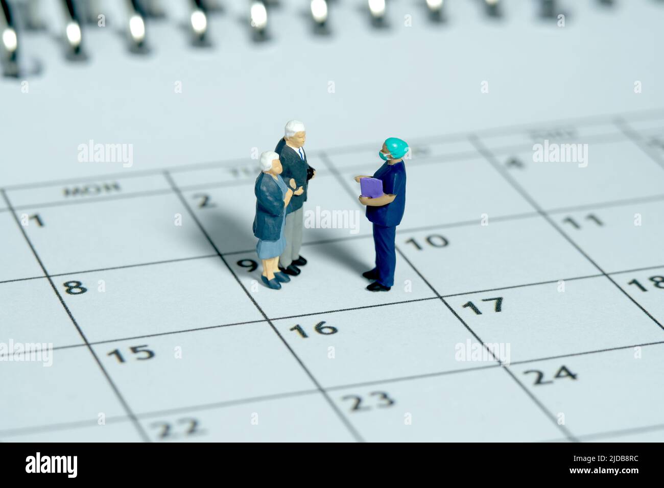 Miniature jouets photographie conceptuelle. Couple de personnes âgées rencontre avec le chirurgien pour déterminer le calendrier de la chirurgie. Médicament et bilan de santé concep Banque D'Images