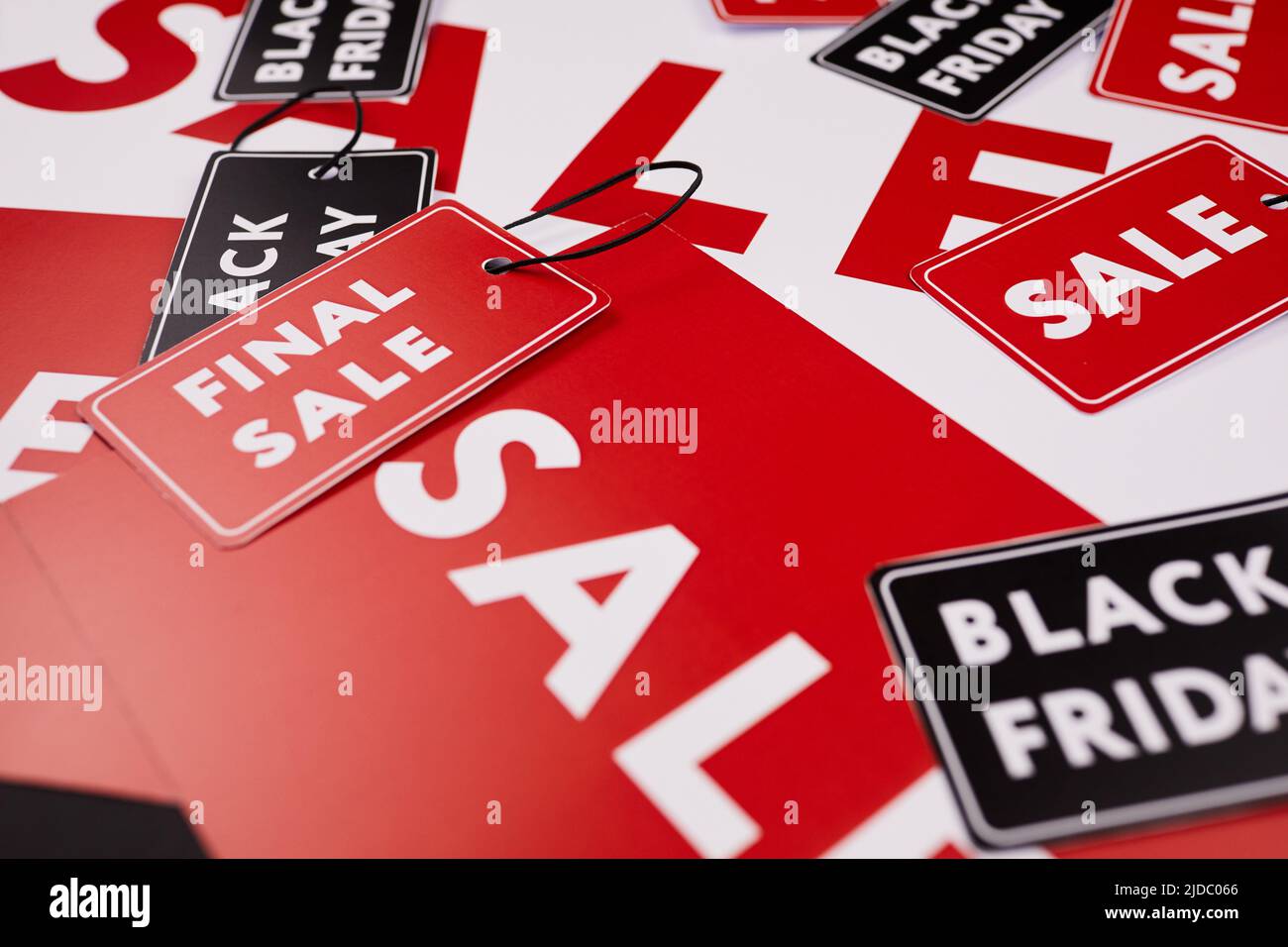 Gros plan des bannières et étiquettes rouges pour la vente au détail, accent sur l'étiquette de vente finale avec une ficelle noire pour la fixation Banque D'Images