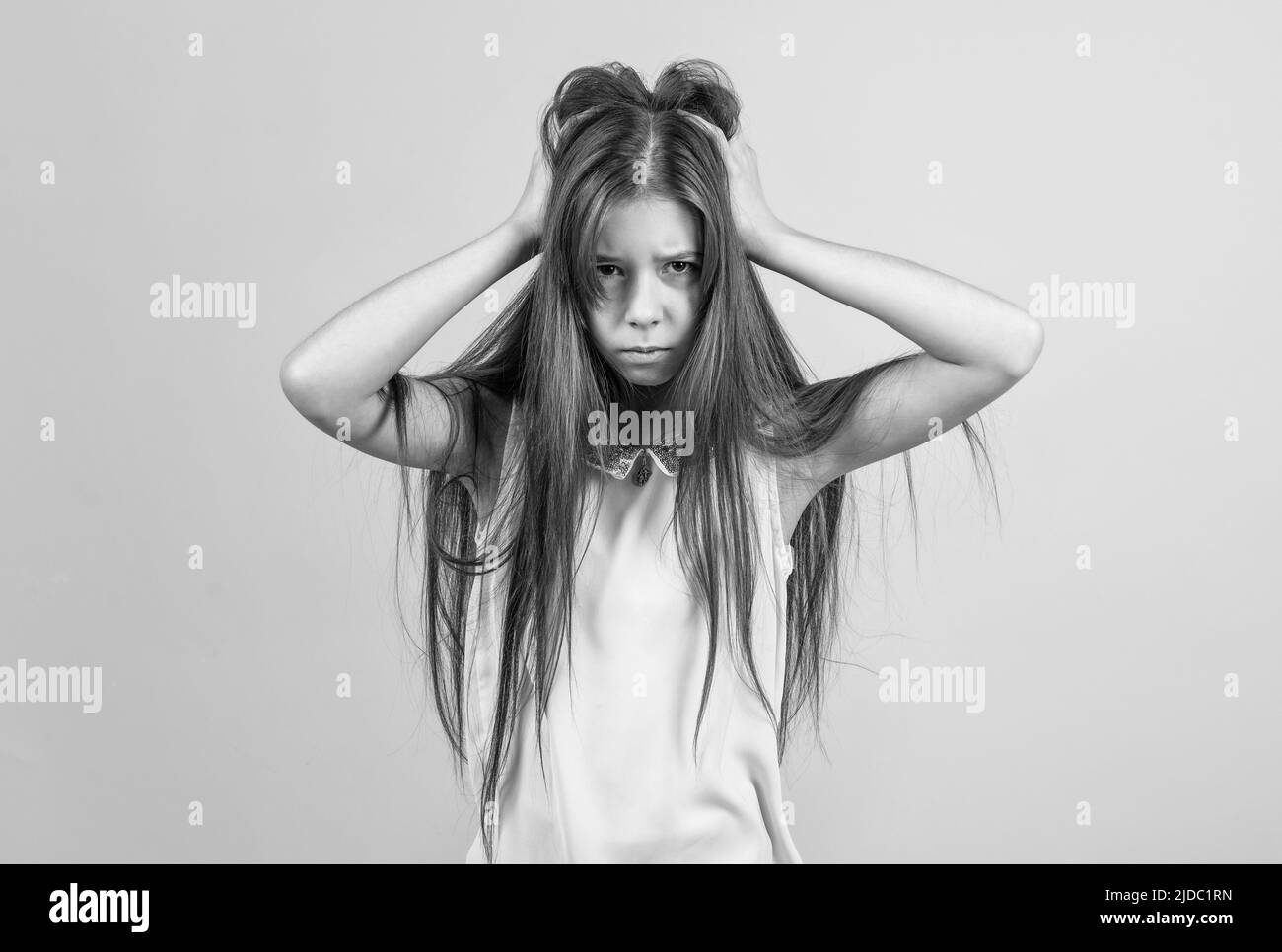 jeune fille triste toucher les cheveux. enfant bouleversé ayant des maux de tête. migraine. malheureux enfant se sentant stressé et surtravaillé. aller fou. concept de coiffeur Banque D'Images