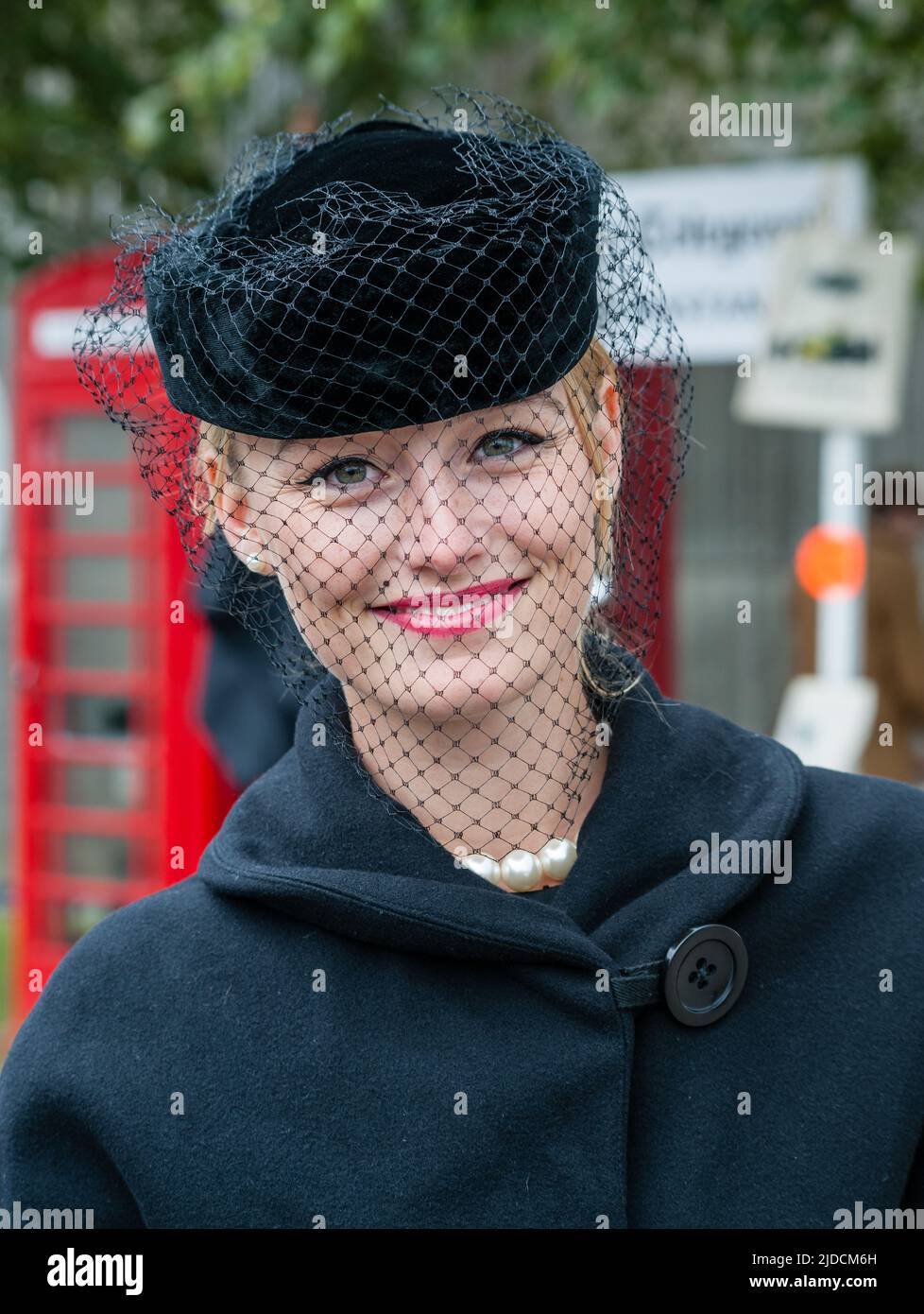 Belle fille dans le costume d'époque des années 1950 et chapeau cloué en filet, à la réunion de Goodwood Revival 2013. Banque D'Images