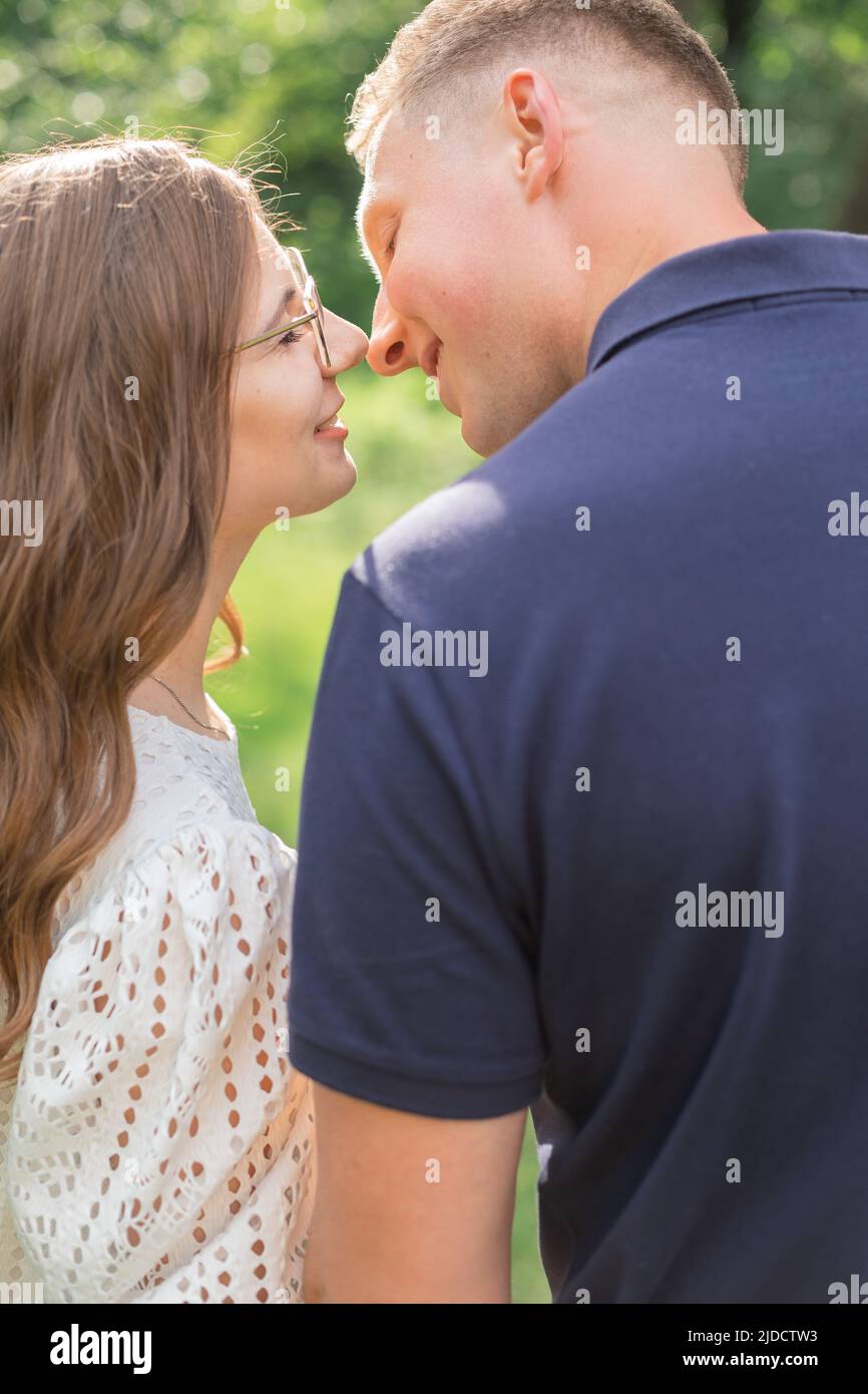 Portrait de jeune couple romantique passionné embrassant et embrassant la marche dans le parc vert en vacances. Banque D'Images