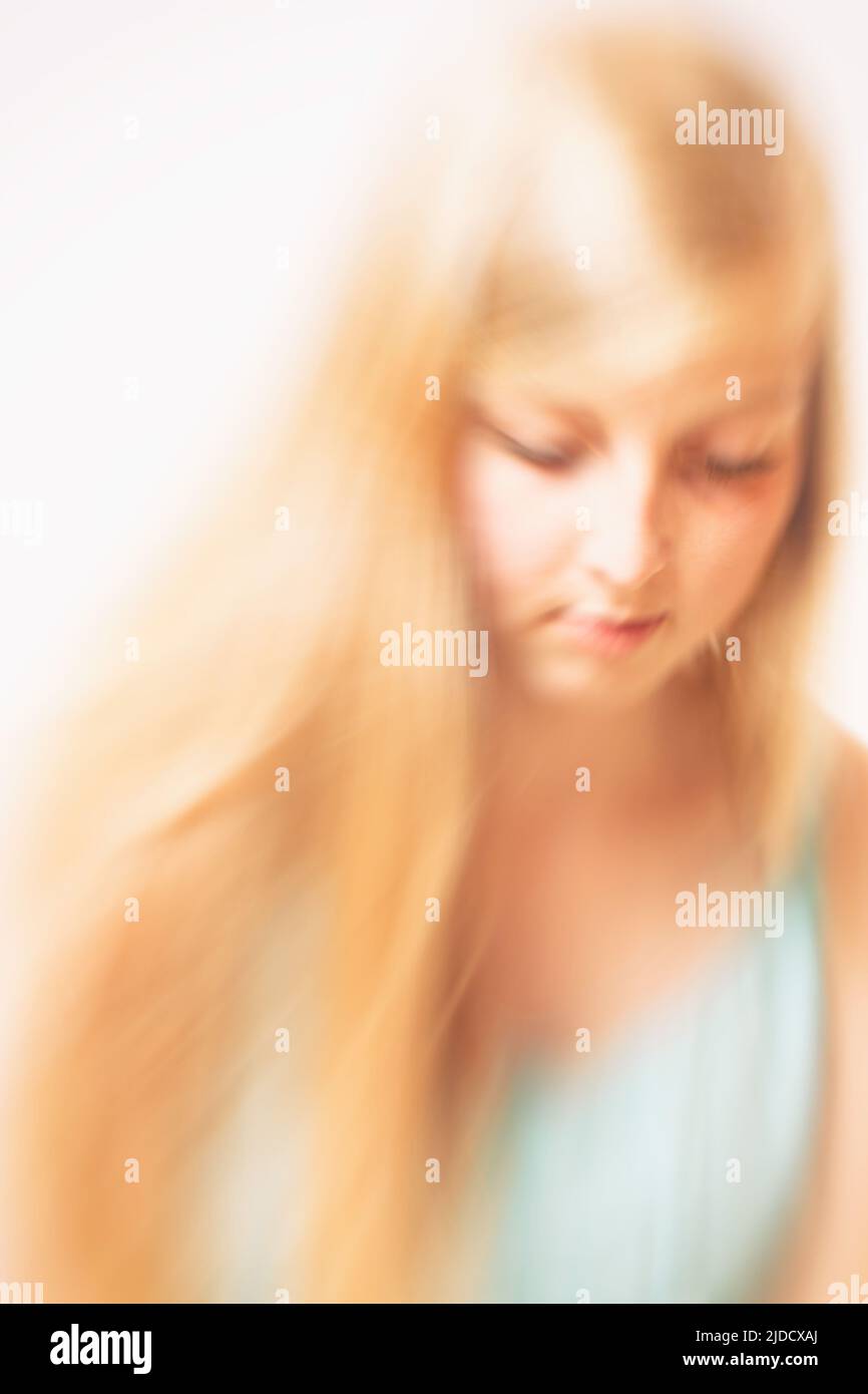 blonde jeune femme portrait soupiré, effet de mouvement flou Banque D'Images
