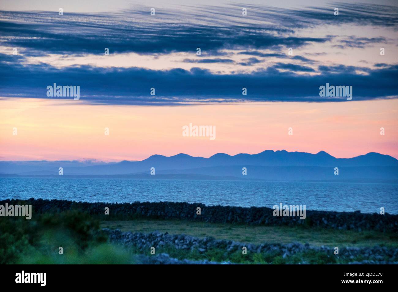 Des murs de pierre ont été silhouetés contre un coucher de soleil à la fin de l'été sur l'île d'Aran à Inishmore dans la baie de Galway, en Irlande. Banque D'Images