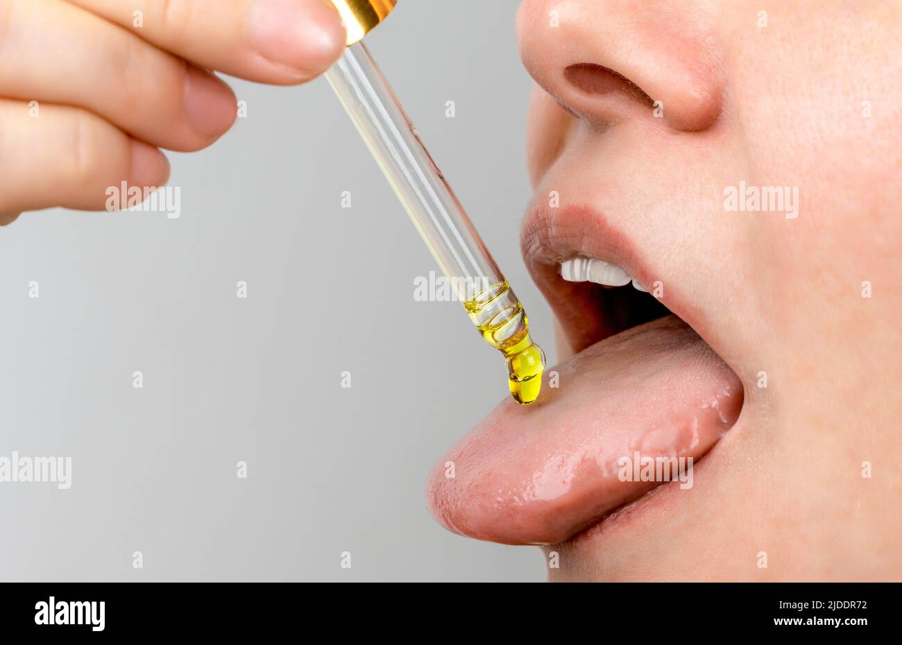 pipette à huile de langue. herbes médecine alternative et compléments alimentaires femme prenant cbd huile de chanvre gouttes dans la bouche de dropper. Supplément et alternance Banque D'Images